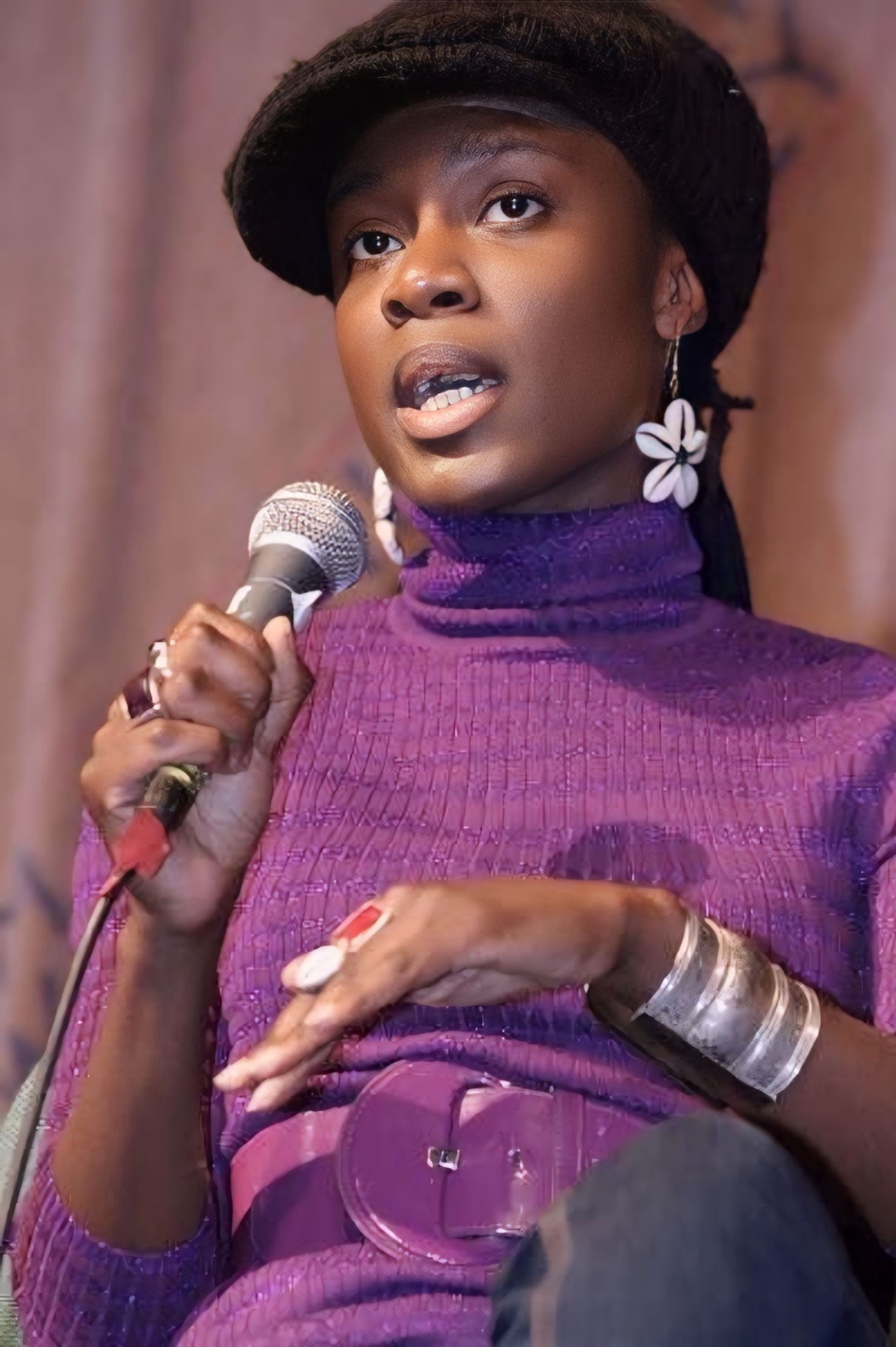 Dami Rock speaking into a microphone on a panel